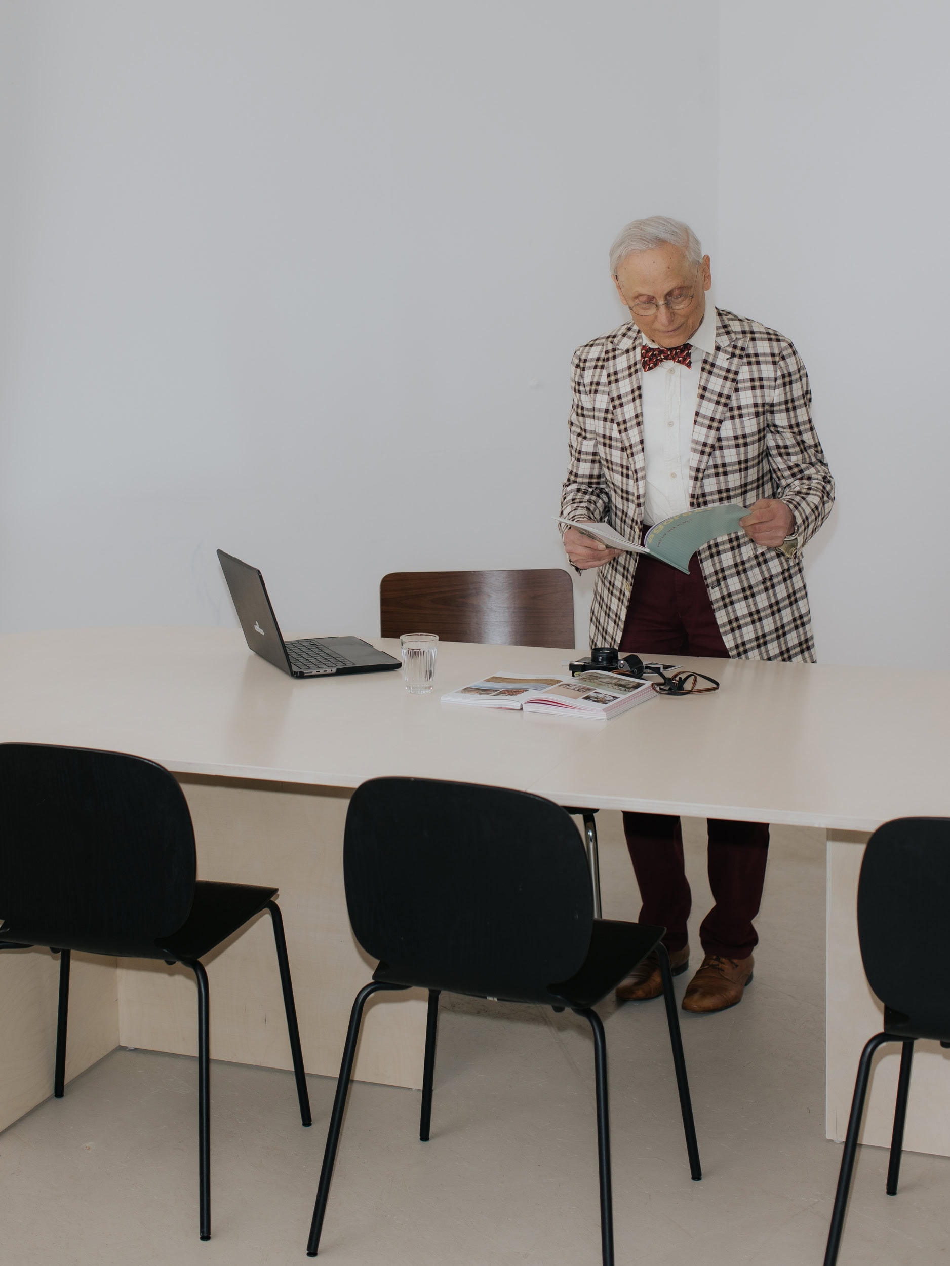 Älterer Mann am Konferenztisch bei einem Fotoshooting im Tageslichtstudio bei Stuttgart