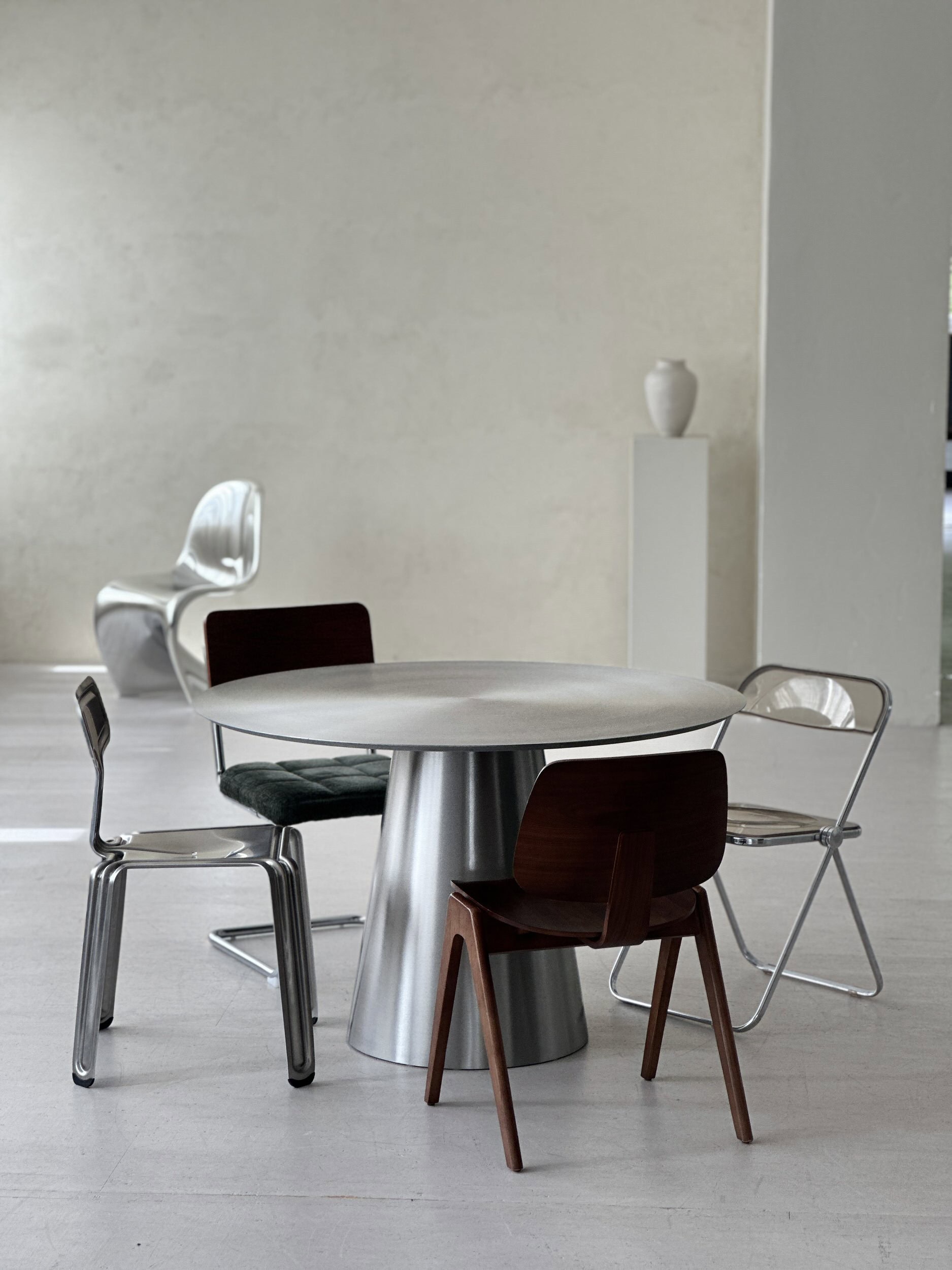 Aluminiumtisch und Designstühle im hellen Tageslichtstudio